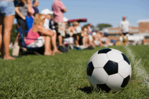 soccer ball in front of parents and fans at a game