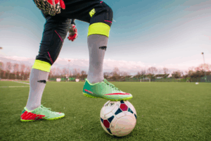 soccer player standing on ball