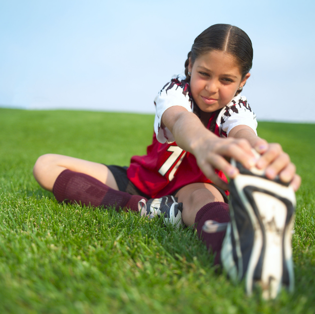 youth girl soccer player stretching