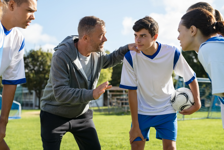 coach talking to his players while handling the opposing sideline youth soccer